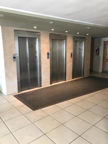 a row of elevators in a room with a tile floor at Hostal del Sol in San Bernardo