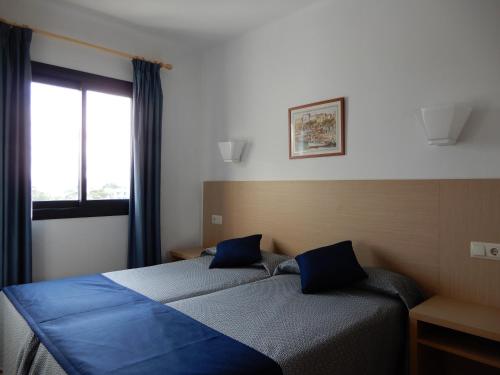 A bed or beds in a room at Marina Palmanova Apartamentos