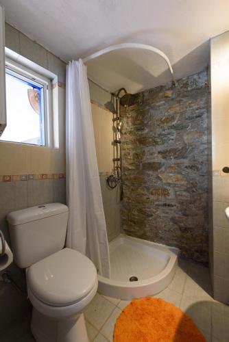 a bathroom with a white toilet and a shower at Villa Marouda in Glossa