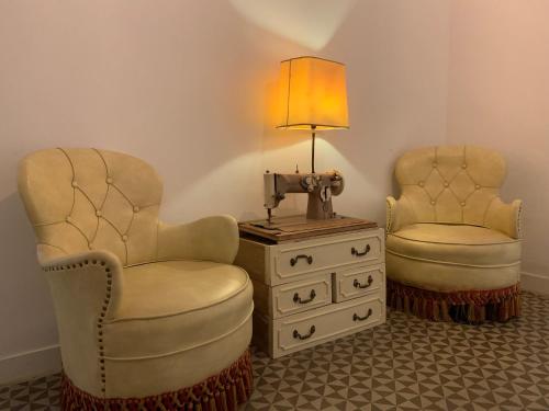 two chairs and a table with a lamp and a dresser at Hostal Portugal in Barcelona