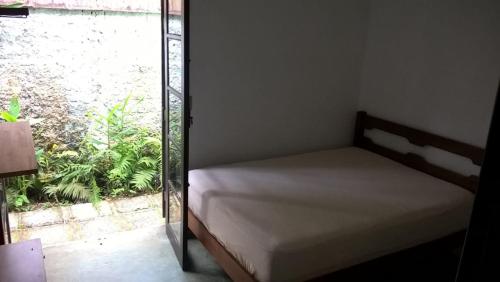 a bed in a room with a window at Casa, quarto inteiro e quarto compartilhado Juréia in Juréia