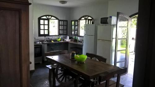 a kitchen with a wooden table with a green bowl on it at Casa, quarto inteiro e quarto compartilhado Juréia in Juréia