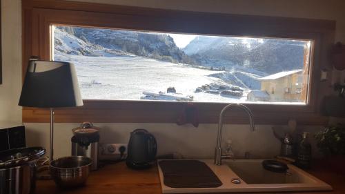 - un comptoir de cuisine avec une fenêtre au-dessus d'un évier dans l'établissement Chalet Ciamarella, à Lanslevillard