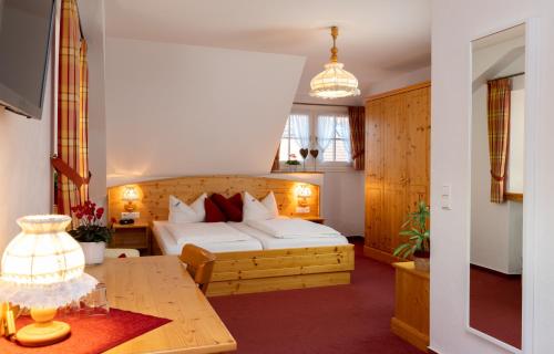 キルヒツァルテンにあるLandgasthof Bärenのベッドとテーブルが備わるホテルルームです。