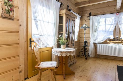 コシチェリスコにあるSmrekowe Domkiのテーブルと椅子、窓が備わる客室です。