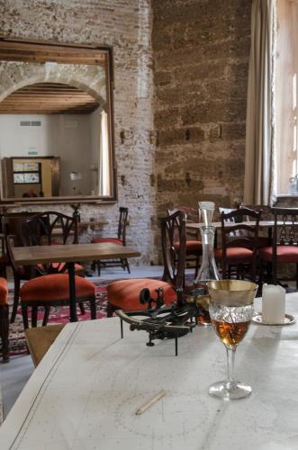 a table with a glass on it with a mirror at Hotel Casa de las Cuatro Torres in Cádiz
