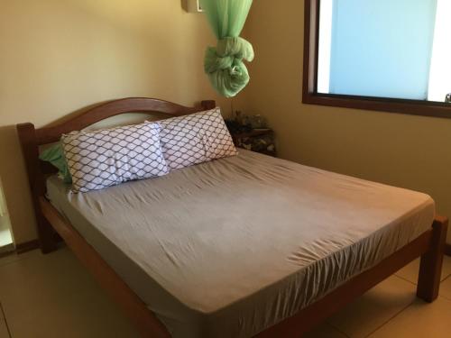 uma cama com duas almofadas num quarto em Casa de praia itacimirim em Itacimirim