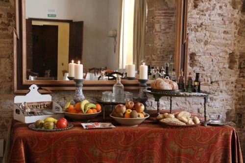 a table with bowls of fruit and candles on it at Hotel Casa de las Cuatro Torres in Cádiz