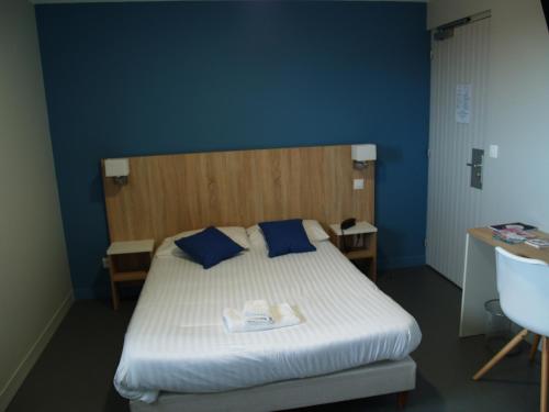 a bedroom with a bed with blue walls and a sink at Le Relais Vauban in Abbeville