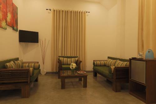 a living room with two couches and a tv at Beach Grove Villas in Unawatuna