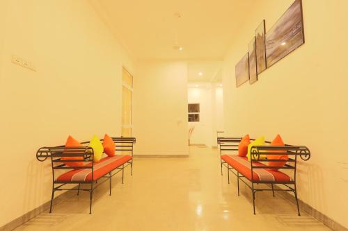 a room with chairs with orange and yellow pillows at Beach Grove Villas in Unawatuna