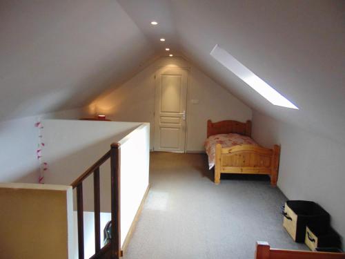 um quarto no sótão com uma cama e uma escada em La Normandy em Dieppe