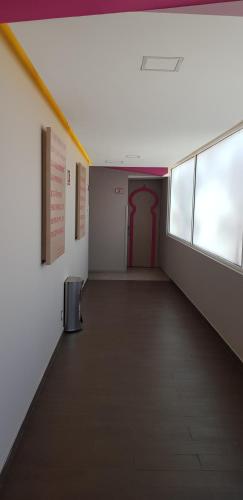 an empty hallway with a red door in a building at Hotel Amala in Mexico City