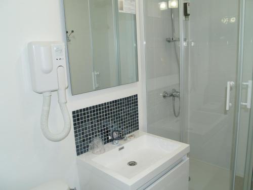 a white bathroom with a sink and a shower at Le Relais Vauban in Abbeville
