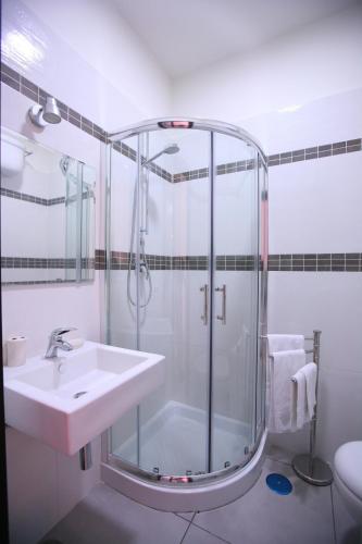 a bathroom with a glass shower and a sink at Megaride Santa Lucia in Naples