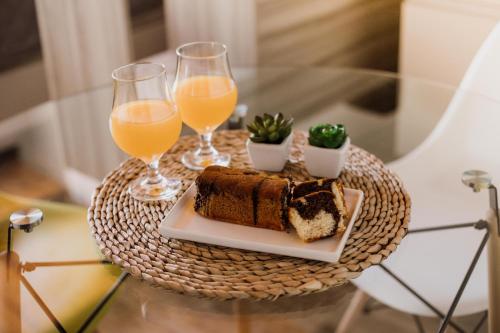 un tavolo con un piatto di torta e due bicchieri di succo d'arancia di Casa Nuestra a Córdoba