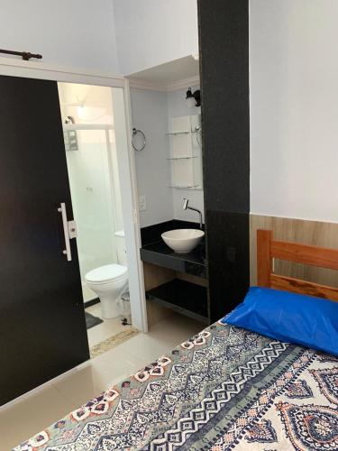 a bathroom with a bed and a sink and a toilet at CASA PÔR DO SOL 1 in Arraial do Cabo