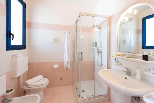 een badkamer met een douche, een toilet en een wastafel bij Scialabà Residence Salento in Torre Pali 
