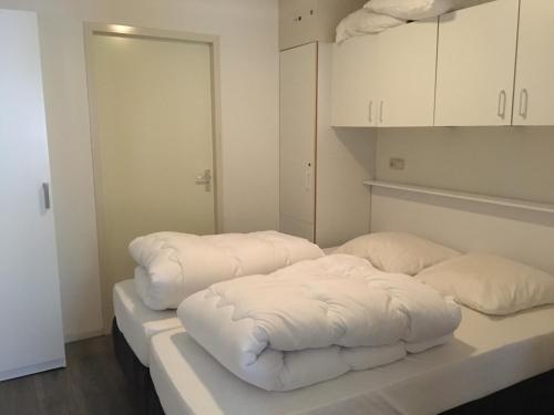 twee witte kussens op een tafel in een kamer bij Appartement De Kompaan, Resort Amelander Kaap in Hollum
