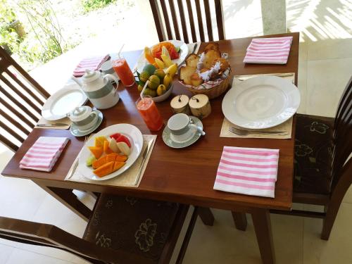 a wooden table with plates of food on it at CASA VACANSA HOME STAY in Hungama