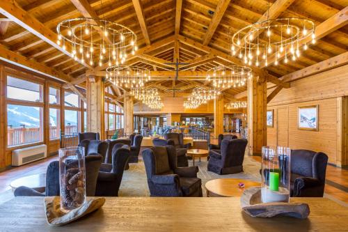 a large room with chairs and tables and chandeliers at Sport Hotel Village in Soldeu