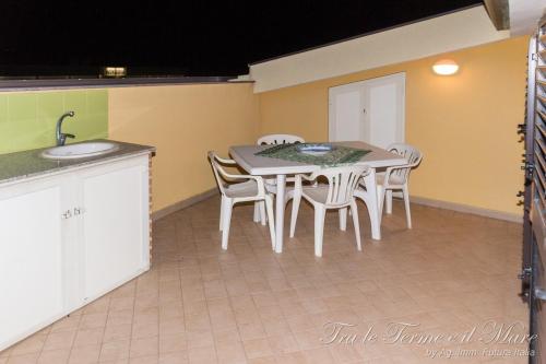 a kitchen with a table and chairs and a sink at Tra le Terme e il Mare in Terme Vigliatore