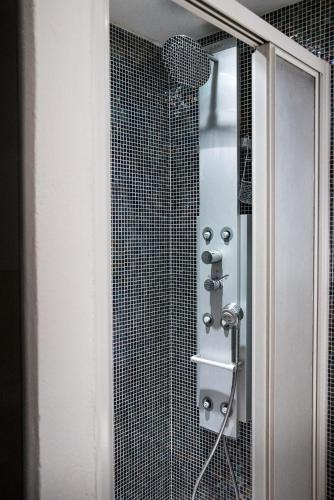 a bathroom with a shower with a glass door at La casa in Camollia in Siena