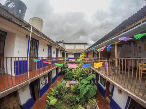Hostel El Nagual في سان كريستوبال دي لاس كازاس: فناء مبنى مزين بالأعلام والنباتات