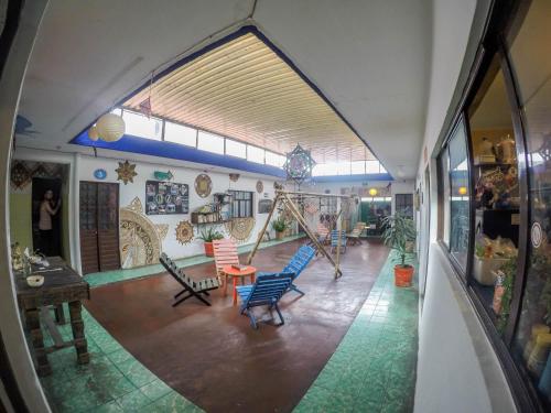 a room with chairs and a swing in a building at Hostel El Nagual in San Cristóbal de Las Casas