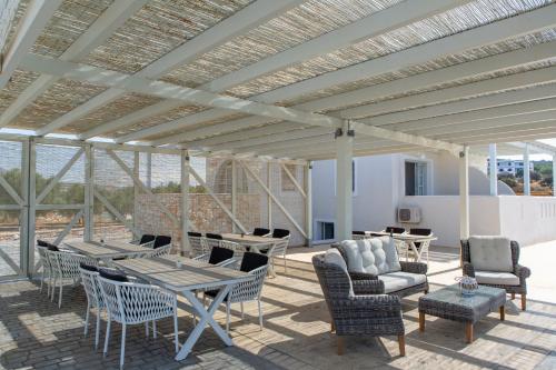 a pavilion with tables and chairs on a patio at Sun and Moon Villas in Aliko Beach
