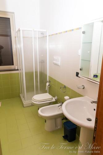 a bathroom with two toilets and a shower and a sink at Tra le Terme e il Mare in Terme Vigliatore