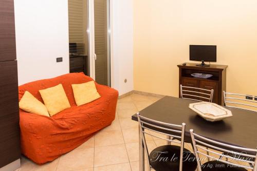 a living room with a orange chair and a table at Tra le Terme e il Mare in Terme Vigliatore