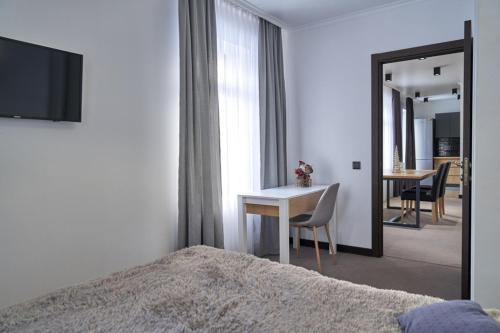 a bedroom with a bed and a desk and a mirror at Villa Gor in Bukovel