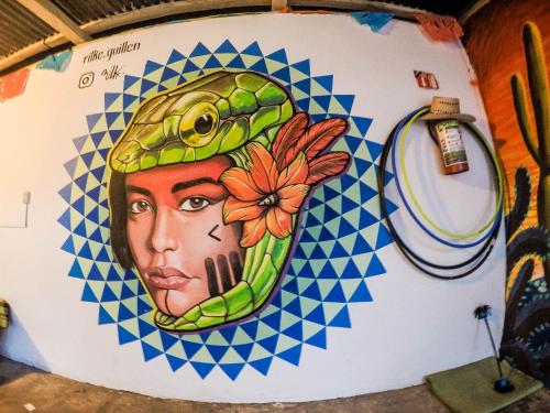 un muro con il dipinto di una donna con una rana in testa di Hostel El Nagual a San Cristóbal de Las Casas