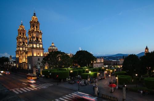 a night view of a city with a building at Hotel Casino Morelia in Morelia