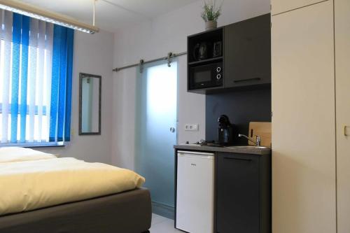 ein Schlafzimmer mit einem Bett und eine Küche mit einer Theke in der Unterkunft Komfort Appartements am Marktplatz in Bexbach