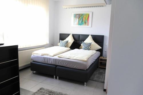 um quarto com uma cama com uma cabeceira preta em Komfort Appartements am Marktplatz em Bexbach