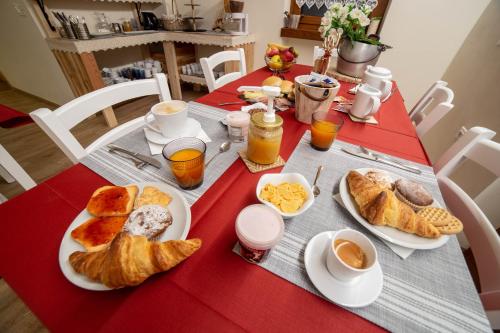 een tafel met borden ontbijtproducten en jus d'orange bij Wanderlust B&B in Folgaria