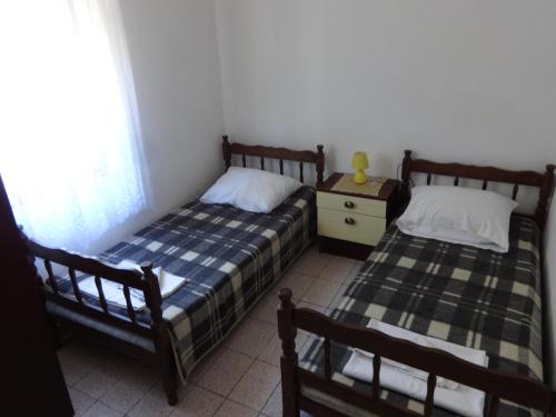 a bedroom with two beds and a table and a window at Apartments Palma in Vir