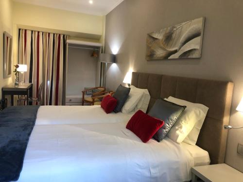 a bedroom with a large white bed with red pillows at Casa Paula Apartments in Lagos