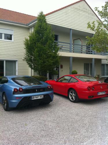 two cars parked in front of a house at Les Jardins d'Ulysse, The Originals Relais in Stella-Plage