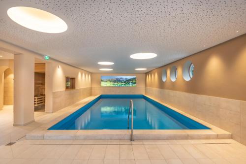 a swimming pool in a hotel room with a ceiling at Bliem's Familienhotel in Haus im Ennstal