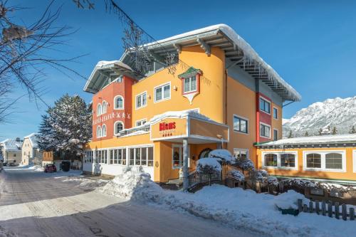 a hotel in the mountains with snow on the ground at Bliem's Familienhotel in Haus im Ennstal