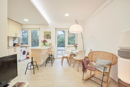 a kitchen and dining room with a table and chairs at Light Apartment With Amazing Balcony, by TimeCooler in Lisbon