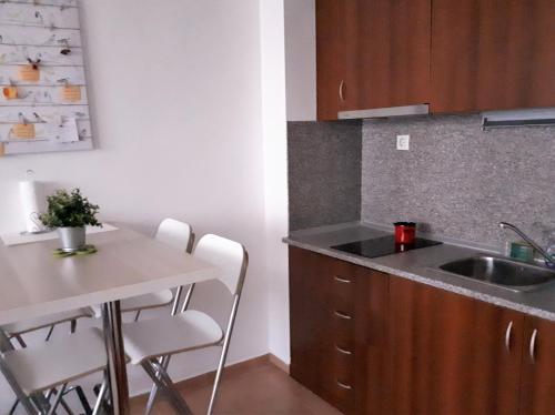 a kitchen with a sink and a table with chairs at Apartment in Infinity Aparthotel in Bansko