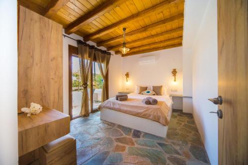 a bedroom with a bed and a large window at Pitropos Garden in Archangelos