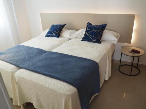 2 Betten mit blauer und weißer Bettwäsche in einem Zimmer in der Unterkunft Los Boliches wifi 300 m playa beach in Fuengirola