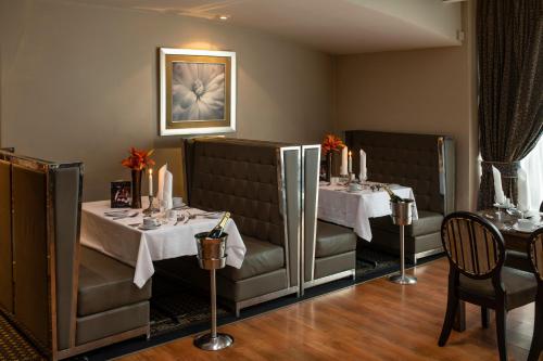 un comedor con 2 mesas con manteles blancos en Wessex Hotel, en Street