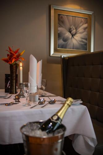 una mesa de comedor con una botella de vino. en Wessex Hotel, en Street