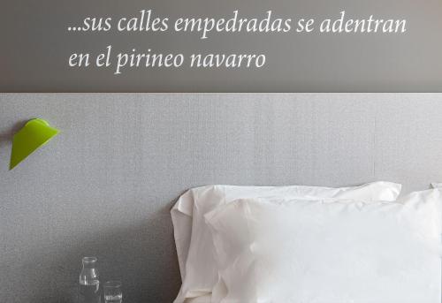 a bedroom with a white bed with a green star above it at ibis Styles Pamplona Noain in Noáin